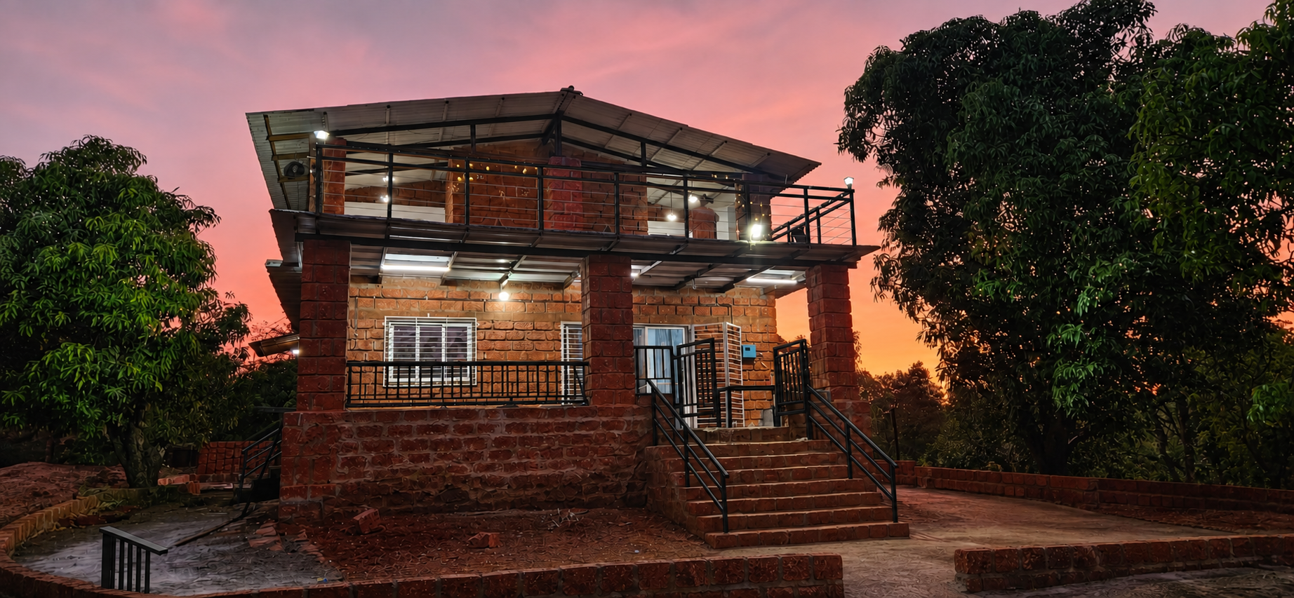Mango Mount farmhouse illuminated beneath a pink dusk sky